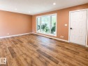 Spacious room featuring wood-finish flooring, recessed lighting, and a large picture window with white trim - 4418 45 Avenue, Bonnyville Town, AB 