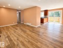 Open concept kitchen and dining area featuring wood-finish flooring, dark wood cabinetry, and a sliding glass door to the exterior - 4418 45 Avenue, Bonnyville Town, AB 