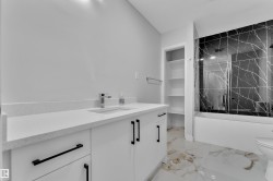 Contemporary bathroom featuring a white vanity with a quartz countertop, under-mount sink, and chrome faucet - 