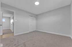 Neutral tone walls with white trim, gray carpet flooring, and a flush mount ceiling light - 