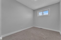 Neutral-toned room with light gray walls, white trim, and gray carpet - 