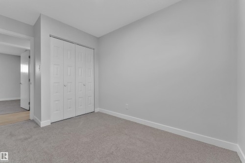 Carpeted interior space featuring light grey walls and white baseboards - 5118 17A Avenue Nw, Edmonton, AB - Indoor Photo Showing Other Room