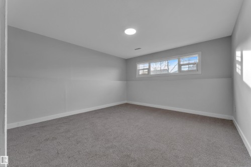 Room featuring gray wall finishes, white trim, gray carpeting, a multi-pane window, and a recessed ceiling light - 5118 17A Avenue Nw, Edmonton, AB - Indoor Photo Showing Other Room