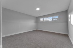 Room featuring gray wall finishes, white trim, gray carpeting, a multi-pane window, and a recessed ceiling light - 