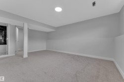Spacious room with new carpeting, light gray walls, white trim, and recessed ceiling lighting - 