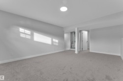 Spacious room with light gray carpeting and white baseboards - 