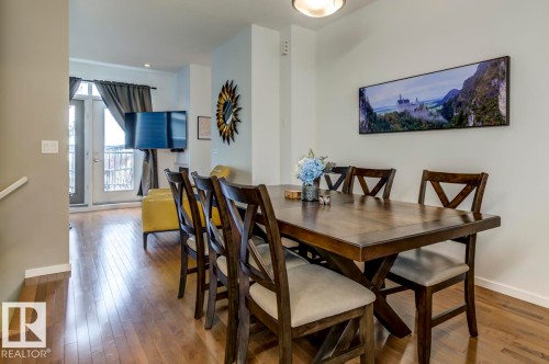 Dining area featuring wood-finish flooring and a contemporary overhead light fixture - 67 603 Watt Boulevard, Edmonton, AB - Indoor Photo Showing Dining Room