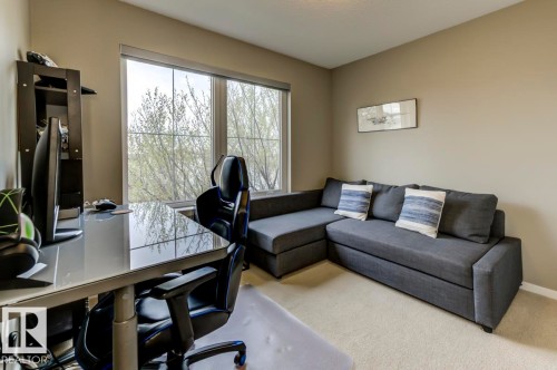 Bright room featuring large window, neutral paint, light carpet, and built-in shelving - 67 603 Watt Boulevard, Edmonton, AB - Indoor