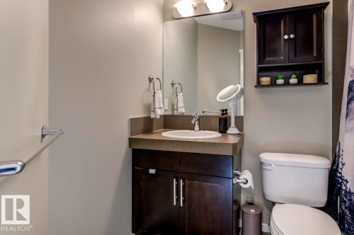 Bathroom featuring a dark wood-finish vanity with an integrated sink and a neutral countertop - 67 603 Watt Boulevard, Edmonton, AB - Indoor Photo Showing Bathroom