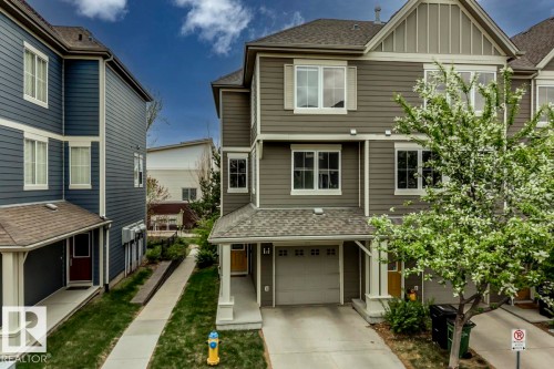 Three-story townhome featuring muted green siding, white trim, and a two-car garage - 67 603 Watt Boulevard, Edmonton, AB - Outdoor