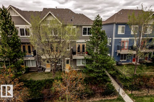 Townhome exteriors featuring multiple levels, balconies with black railings, and a mix of siding materials - 67 603 Watt Boulevard, Edmonton, AB - Outdoor