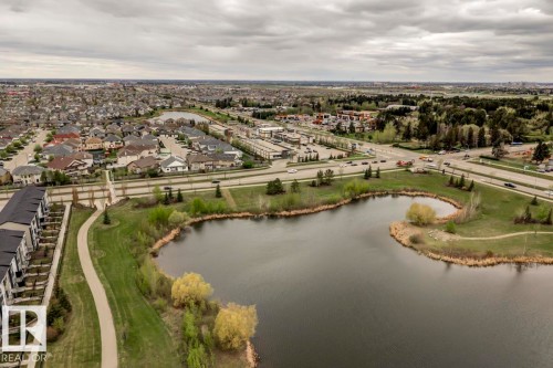 Expansive aerial capturing a neighborhood with varied residential structures and a large body of water - 67 603 Watt Boulevard, Edmonton, AB - Outdoor With Body Of Water With View