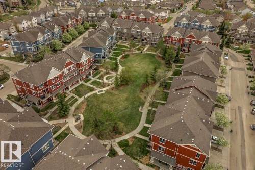 Aerial perspective of a residential development featuring townhomes surrounding a central green space - 67 603 Watt Boulevard, Edmonton, AB - Outdoor With View