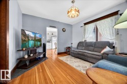 Hardwood-finish flooring, light blue wall paint, a window with blinds and lace curtains, and a ceiling-mounted light fixture - 