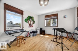 Bright room featuring wood-finish flooring, white walls, and multiple windows with brown wood trim - 