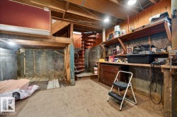 Spacious unfinished basement featuring exposed wood beams and concrete walls - 