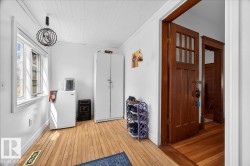Bright interior space featuring light wood-finish flooring, white walls, and a paneled ceiling - 
