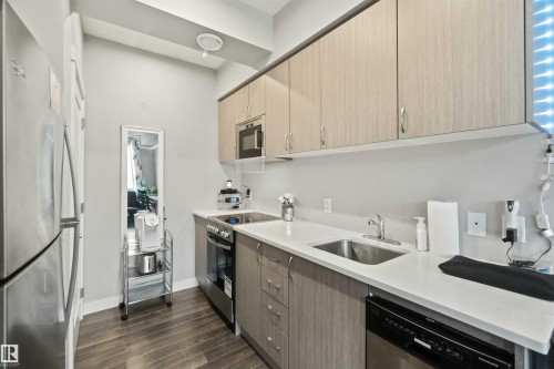 Modern kitchen featuring stainless steel appliances, light-toned cabinetry, white countertops, a stainless steel sink, and wood-finish flooring - 456 Allard Boulevard, Edmonton, AB - Indoor Photo Showing Kitchen With Upgraded Kitchen