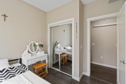 Interior space featuring dark wood-finish flooring, a mirrored closet door, and light neutral wall paint - 