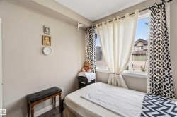 Bright room featuring a large window, neutral wall paint, and dark wood-finish flooring - 