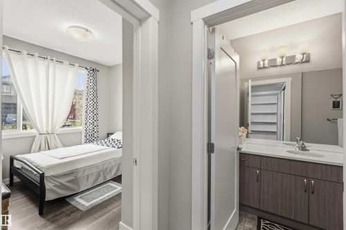 Contemporary bathroom vanity featuring a quartz countertop, integrated sink, and dual-door storage cabinetry - 456 Allard Boulevard, Edmonton, AB - Indoor