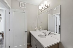 Dual vanity with integrated sinks, light-toned countertop, and wood-finish cabinetry - 