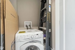 Laundry area with a front-loading washing machine, water hookups, and neutral wall tones - 