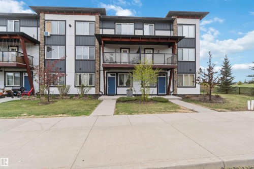 Contemporary multi-story exterior featuring a mix of white siding, dark paneling, and stone accents - 456 Allard Boulevard, Edmonton, AB - Outdoor With Facade