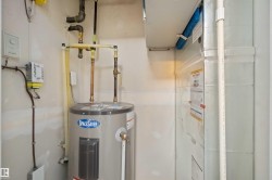 Utility closet featuring a water heater, associated piping, and a visible HVAC unit - 