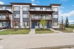 Contemporary multi-level exterior with a mix of white siding, dark paneling, and stone accents - 