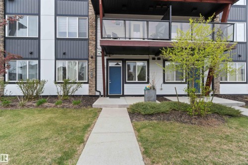 Multi-level exterior featuring white siding, dark grey vertical panels, and stone accents - 456 Allard Boulevard, Edmonton, AB - Outdoor With Facade