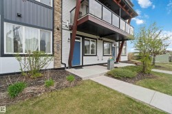Multi-level exterior featuring light-colored siding, dark accent paneling, and a stone-clad column - 