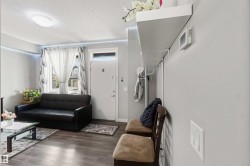 Entryway area featuring wood-finish flooring, a white entry door with frosted glass transom, and an overhead lighting fixture - 