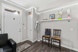 Entryway featuring wood-finish flooring, light grey walls, and white trim - 
