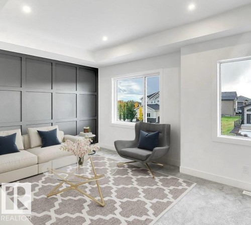Living area featuring a dark paneled accent wall, recessed ceiling lighting, and light-colored carpeting - 13011 186 Avenue, Edmonton, AB - Indoor Photo Showing Living Room