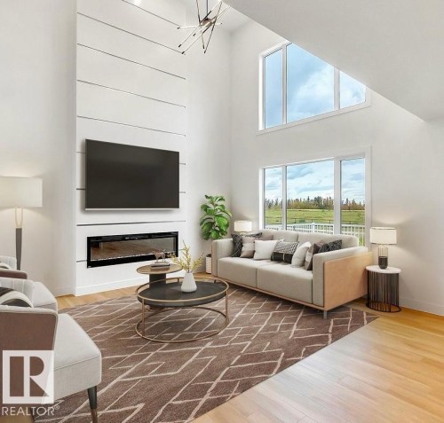 Living area featuring a floor-to-ceiling fireplace with integrated television, vaulted ceilings, and light wood-finish flooring - 13011 186 Avenue, Edmonton, AB - Indoor Photo Showing Living Room With Fireplace