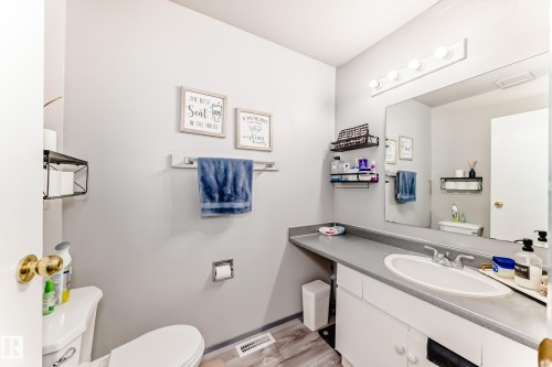 Bathroom featuring a single vanity with an integrated sink, a gray countertop, and white cabinetry - 214A Warwick Road, Edmonton, AB - Indoor Photo Showing Bathroom