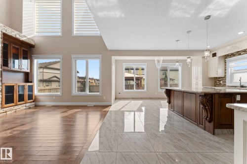 Open-concept living space featuring high ceilings and a blend of wood-finish flooring and large format tile - 16543 132 Street, Edmonton, AB - Indoor