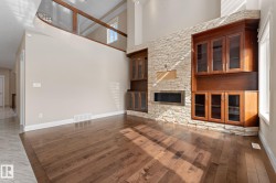 Spacious interior featuring wood-finish flooring and a two-story ceiling - 