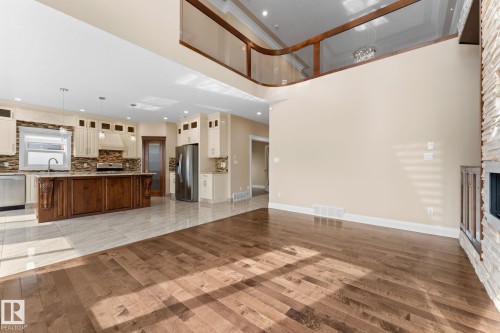 Open-concept living space with wood-finish flooring - 16543 132 Street, Edmonton, AB - Indoor Photo Showing Kitchen With Fireplace