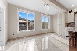 Open-concept dining area featuring large windows, high-gloss tile flooring, and an elegant chandelier - 