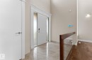 Grand entryway featuring a double-height ceiling, polished tile flooring, and a contemporary entry door with sidelights - 16543 132 Street, Edmonton, AB  - Indoor Photo Showing Other Room 
