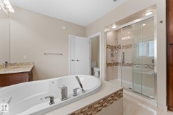 Soaking tub with chrome fixtures, tiled surround, and integrated jets - 