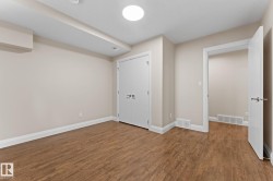 Room featuring wood-finish flooring, light-toned walls, and white trim - 