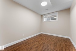 Room featuring wood-finish flooring, neutral wall tones, and white baseboards - 
