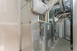 Mechanical room featuring a water heater, furnace, and extensive ductwork - 