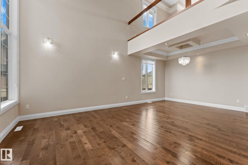 Spacious interior featuring a two-story ceiling, wood-finish flooring, and a second-level open balcony - 16543 132 Street, Edmonton, AB - Indoor Photo Showing Other Room