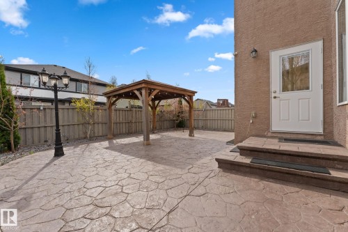 Expansive stamped concrete patio featuring a wooden gazebo, a decorative lamppost, and a privacy fence - 16543 132 Street, Edmonton, AB - Outdoor