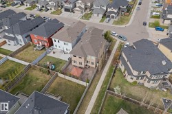 Fenced backyard featuring a paved patio with an attached gazebo and a grassy lawn - 
