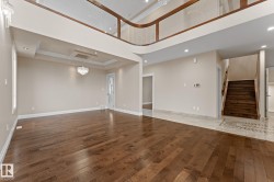 Expansive open-concept interior featuring wood-finish flooring and a two-story ceiling - 
